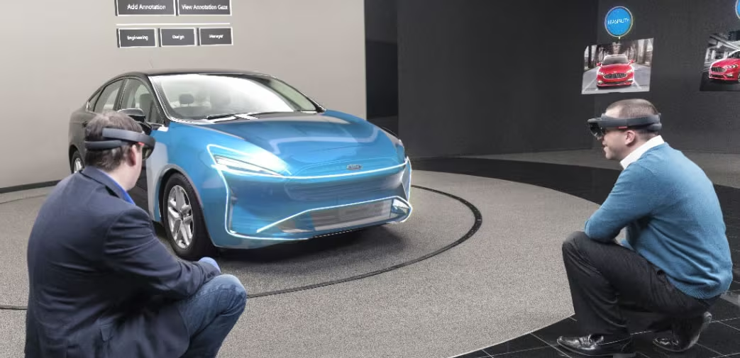 A photo of two designers discussing elements of a New Ford Vehicle using holograms overlaid on a production car.