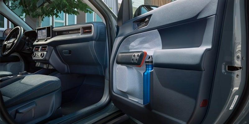 Ford Meveric front two seats interior is displayed from open door.