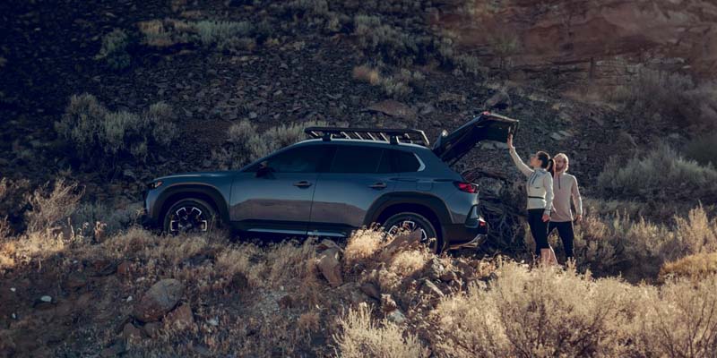 Couple unloading SUV in a rocky desert landscape during daylight adventure