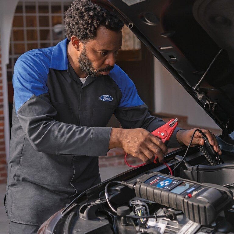 mobile service tech working on car Borgman Ford Mazda in Grandville MI