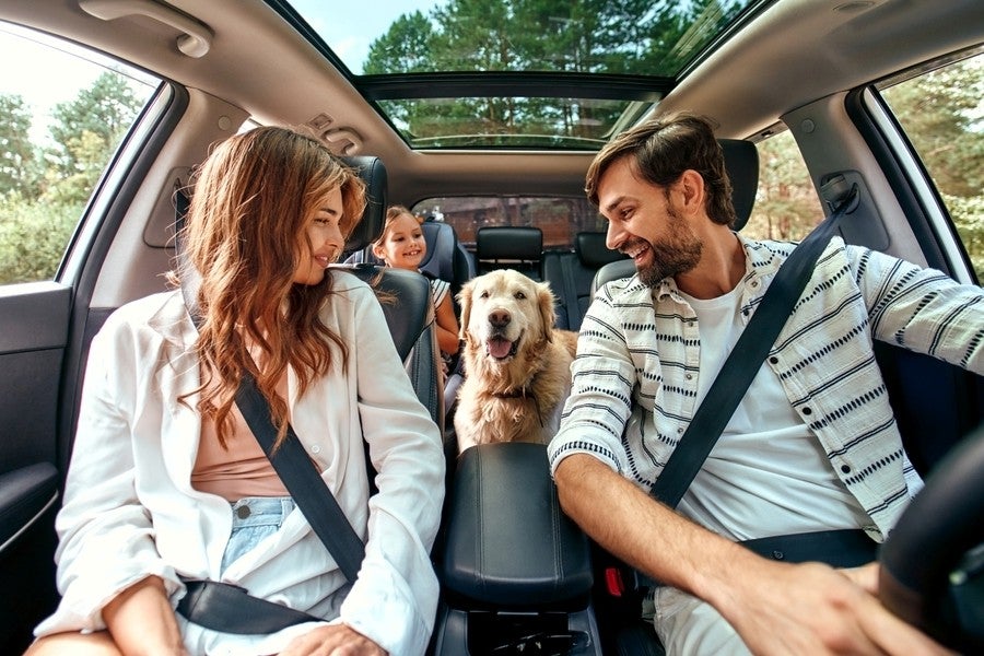 A women sitting inside car happily receiving a car key.